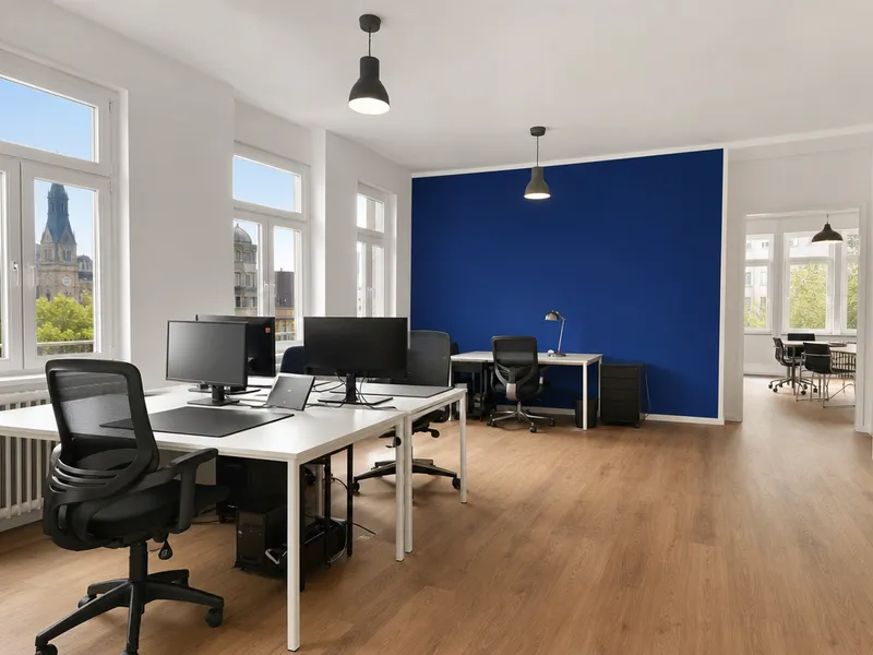 Frisch gestrichenes Großraumbüro mit blauer Akzentwand, Arbeitsplätzen und Tageslicht.